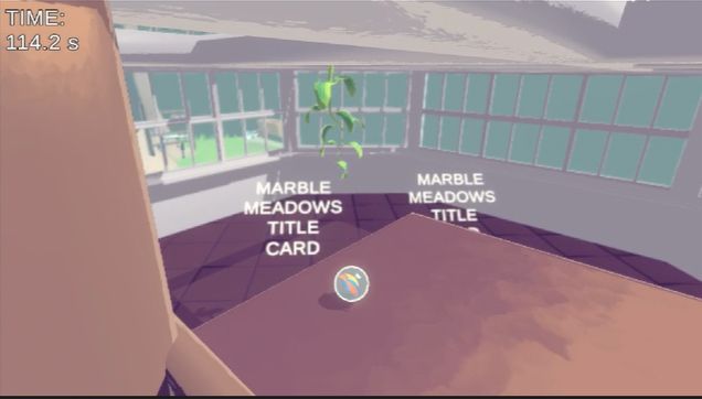 A marble sitting on a ledge looking over an empty room with totally not temporary asset cards that read "MARBLE MEADOWS TITLE CARD"