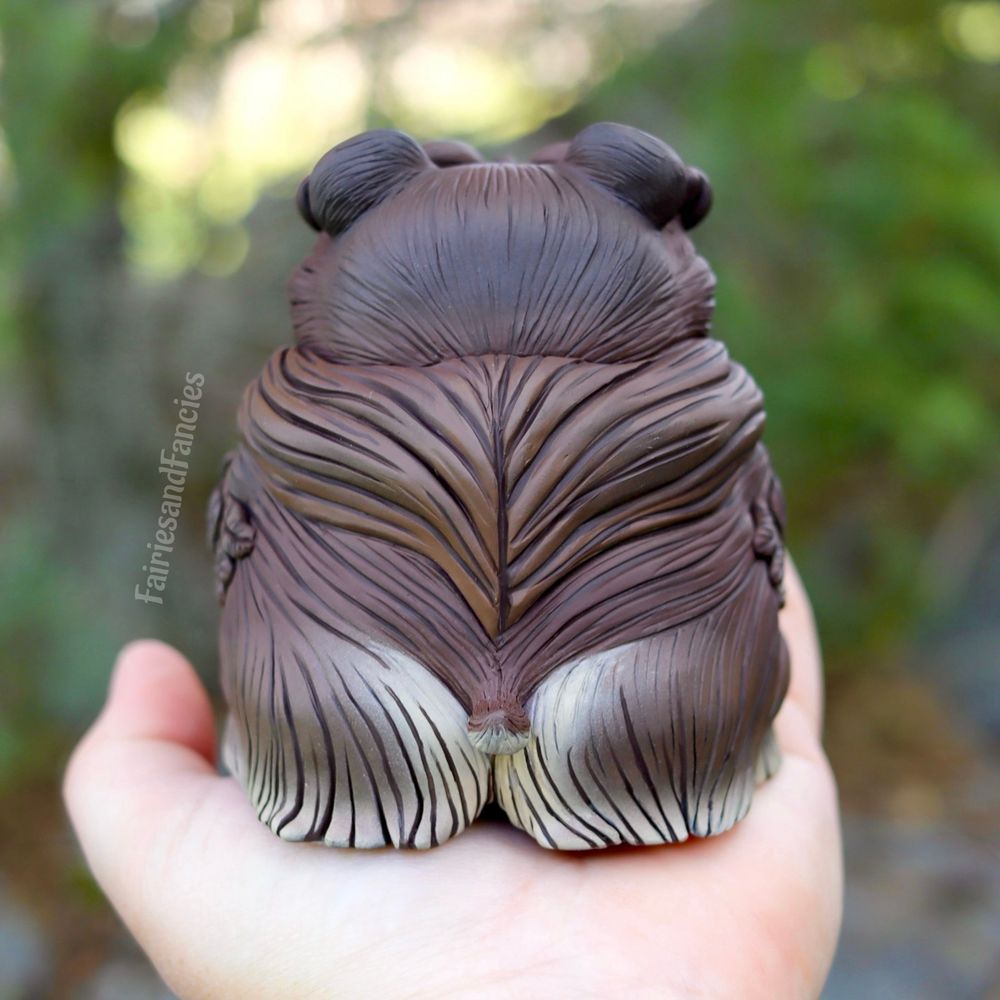 Photo of a sculpture about 5 inches tall of a baby version of the d and d owl bear from behind showcasing its adorable booty and tiny tail. 