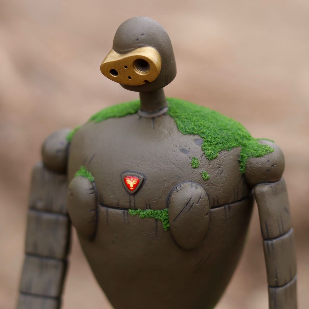 Photo of a sculpture of a Laura robot, a close up of his shoulders and head. 