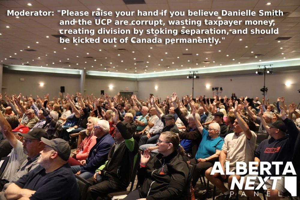 A photo of a seated crowd of people raising their hands in the air. The caption reads: Moderator: Please raise your hand if you believe Danielle Smith and the UCP are corrupt, wasting taxpayer money, creating division by stoking separation, and should be kicked out of Canada permanently. 
