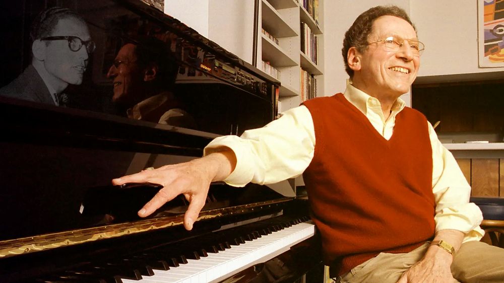 Tom Lehrer at his piano in 2000, with an earlier B/W photo of him superimposed on the left