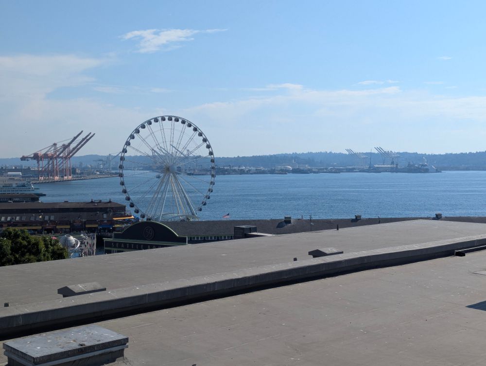 The waterfront with a pale blue sky and a ferris wheel.