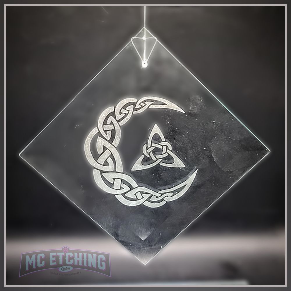 product photo of a diamond shaped glass suncatcher  etched with a knotwork crescent moon and triquetra design