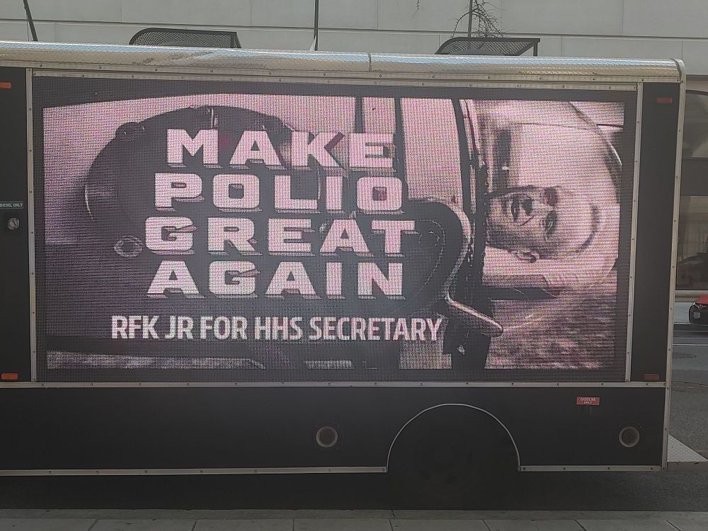 A box truck is parked on a street and bears an electronic sign reading: "Make polio great again/ RFK Jr for HHS Secretary.'