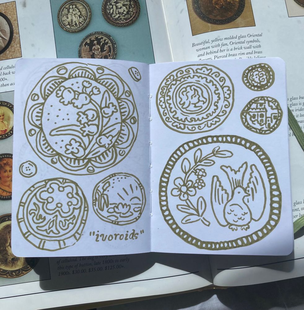 Buttons on this page drawn in green brush pen, with the word “ivoroids” in quotes (apparently what this type of button is called). Designs include a dove, bell shaped flowers, and a lily pond sunrise. 