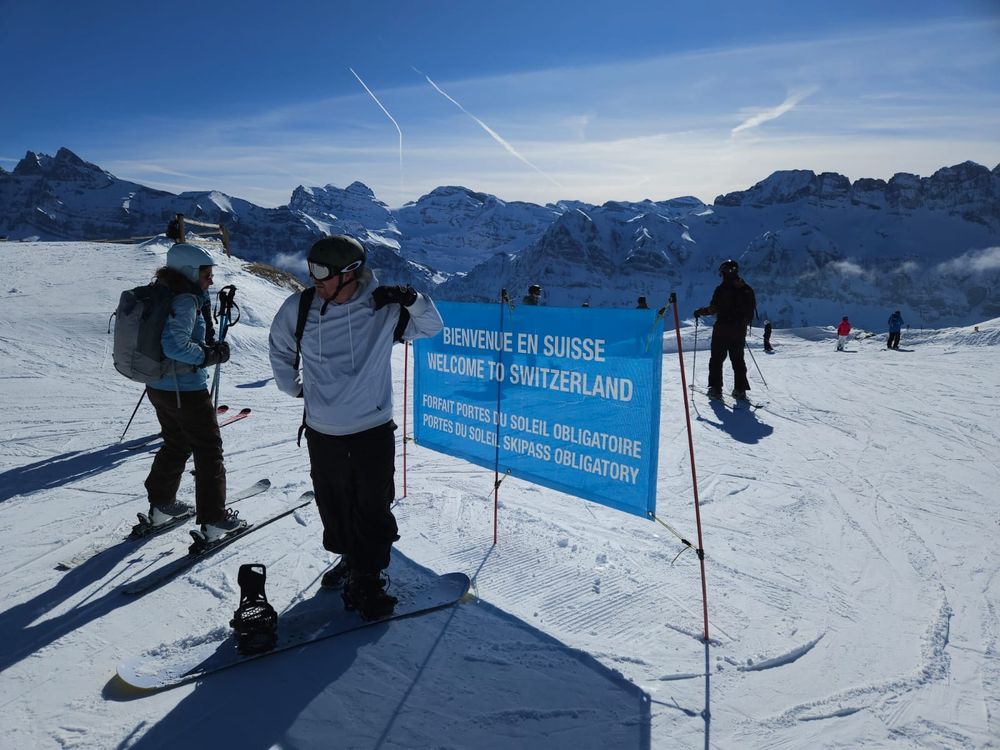 Boarding chum stood next to a "Welcome to Switzerland" sign at the top of a ski run at the border with France.