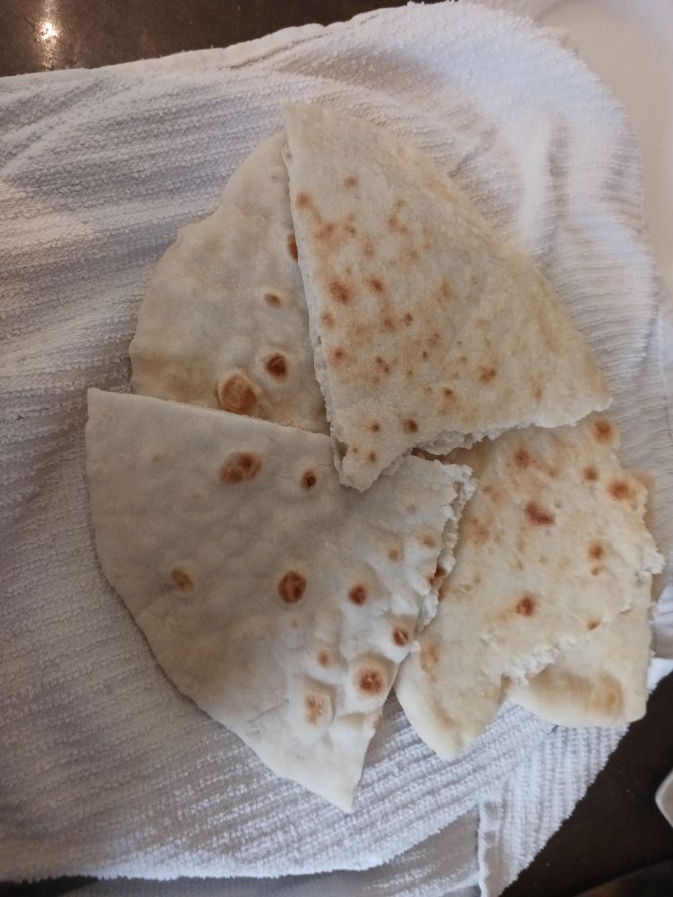 Quarters of roti on white dish towels.