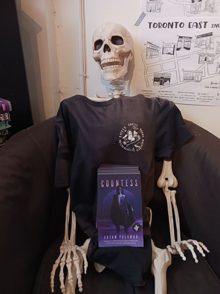 A picture of mary the little ghost book's shop skeleton with signed copies of Countess on her lap!