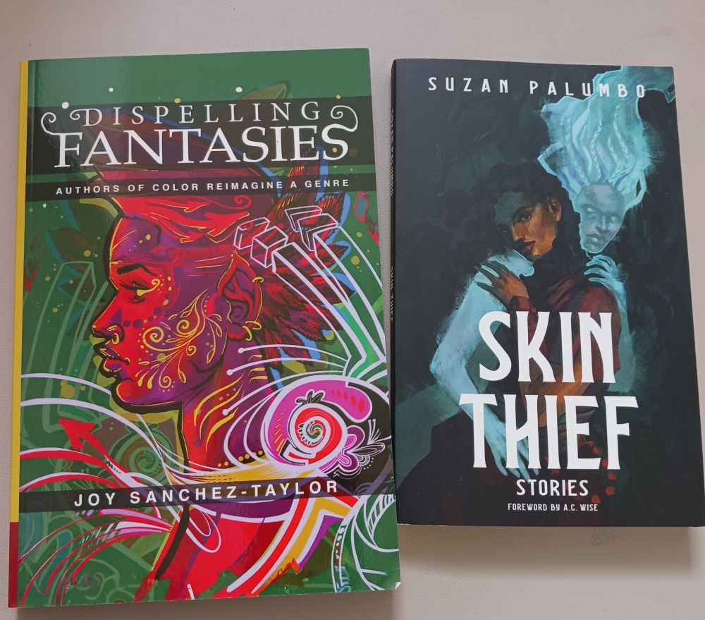 A picture of Dispelling Fantasies: Authors of Color Reimagine a Genre and Skin Thief: Stories next to each other on my desk.
