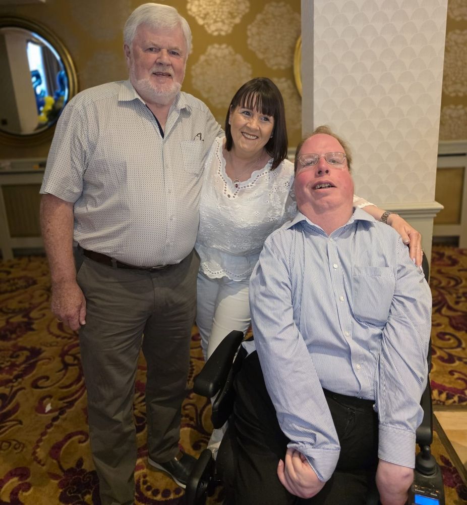 A wheelchair user with two other people in an event room.