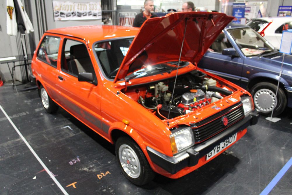 A red MG Metro with it's bonnet up. 