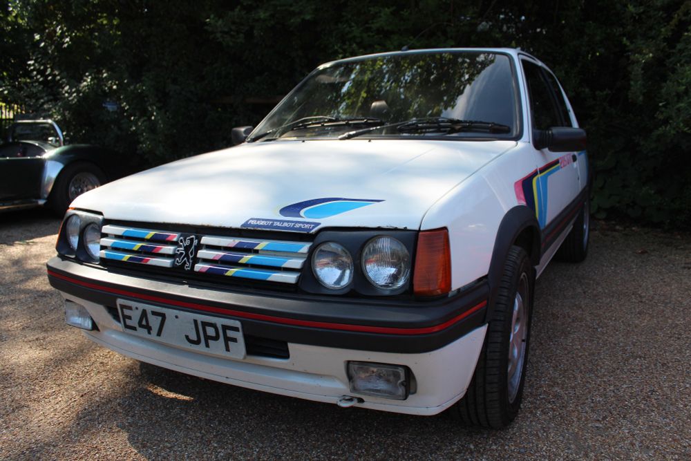 A white Peugeot 205 GTi with Peugeot Talbot Sport decals. 