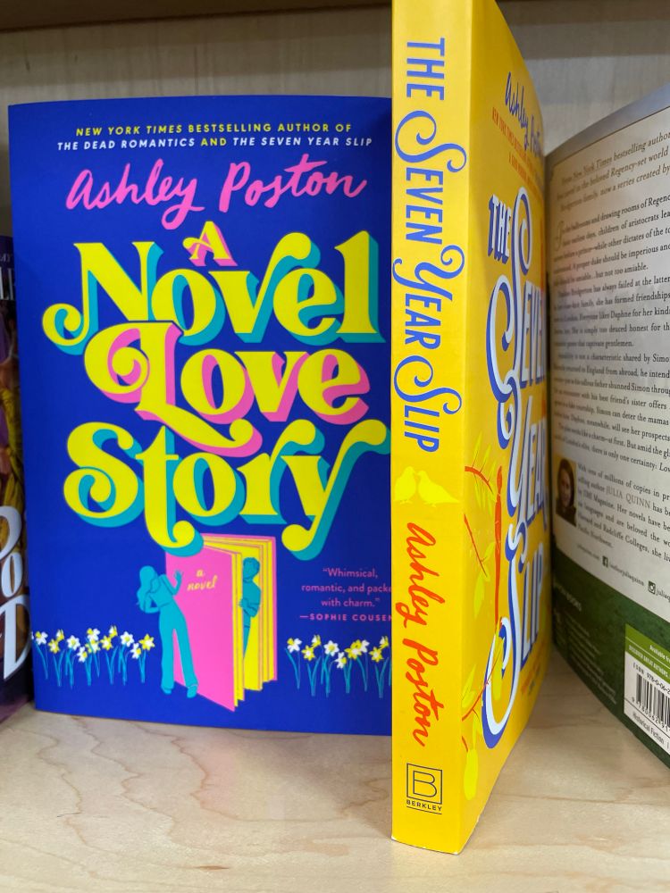 Two books on a shelf in Sherman’s Bookstore in Topsham Maine by author Ashley Poston: A Novel Love Story and The Seven Year Slip