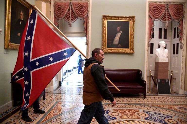 Man carrying the Confederate flag through the US Capitol Building on January 6th, 2021.