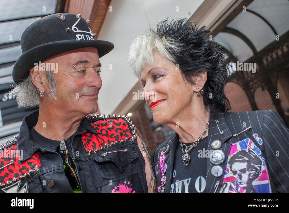 Two old punk rockers smiling at each other