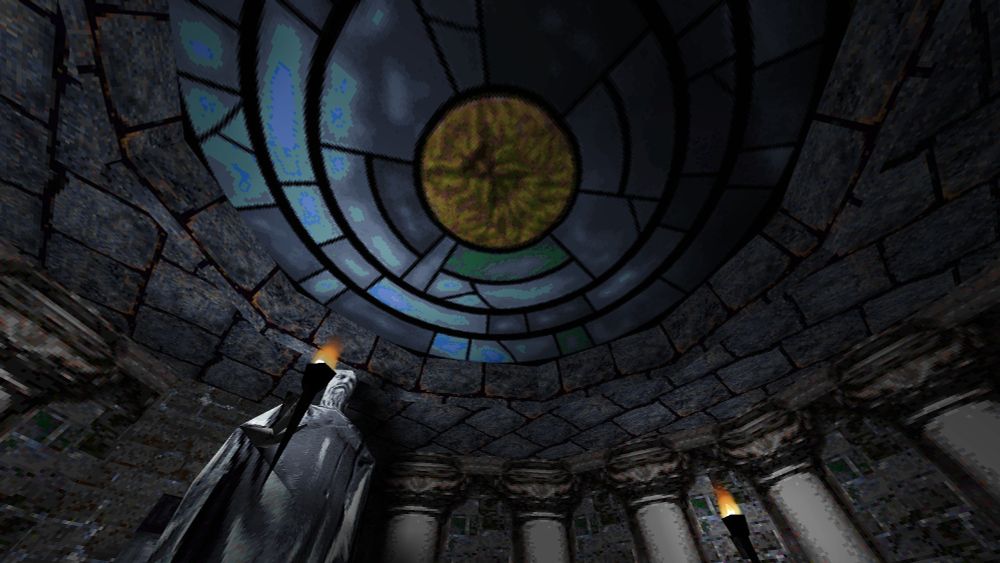 A circle stone room, lined with pillars. A stained glass window is set inside the ceiling of the room. A lone statue holds a torch.

Screenshot by Scoop