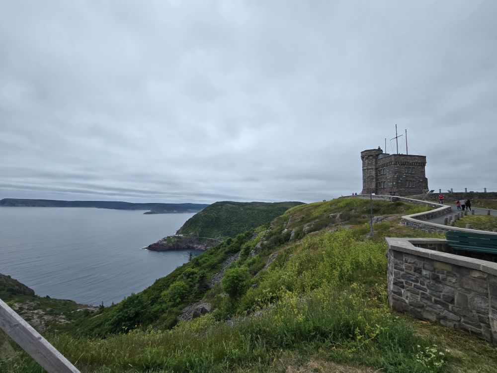 Signal hill on a cloudy day and cape spear behind it.