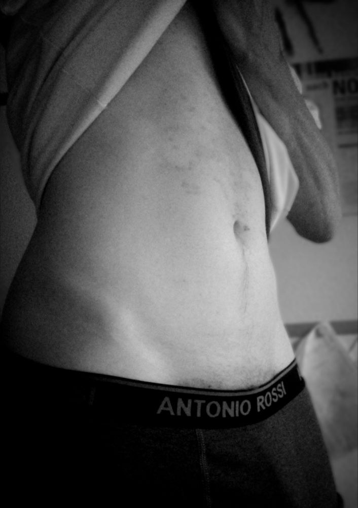 Black and white picture of a person pulling its shirt up to its chest pants hanging low with gray boxer briefs and a flat tummy with a hint of V lines.