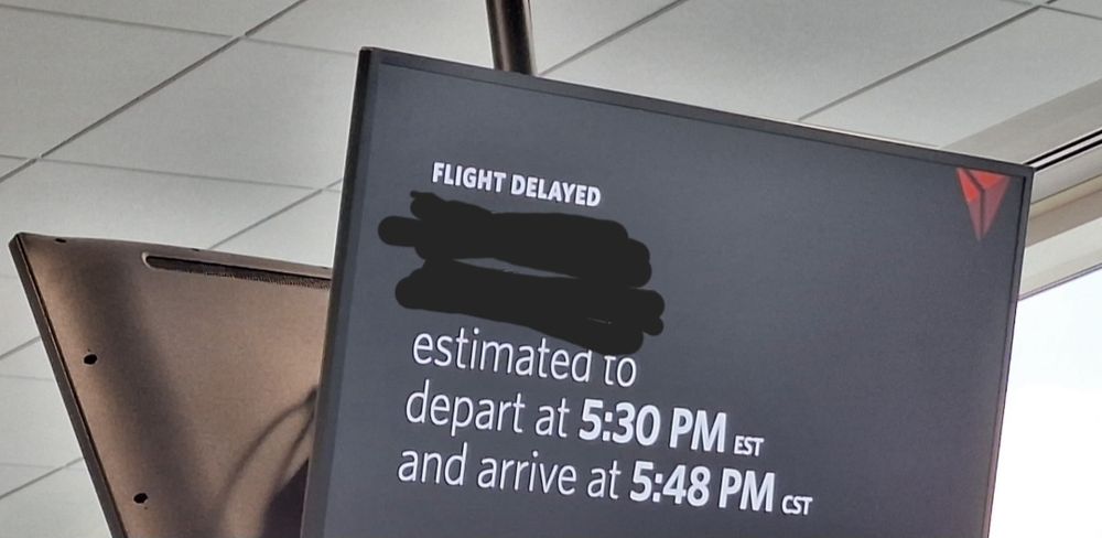 Delta flight sign saying delayed departure at 5:30pm