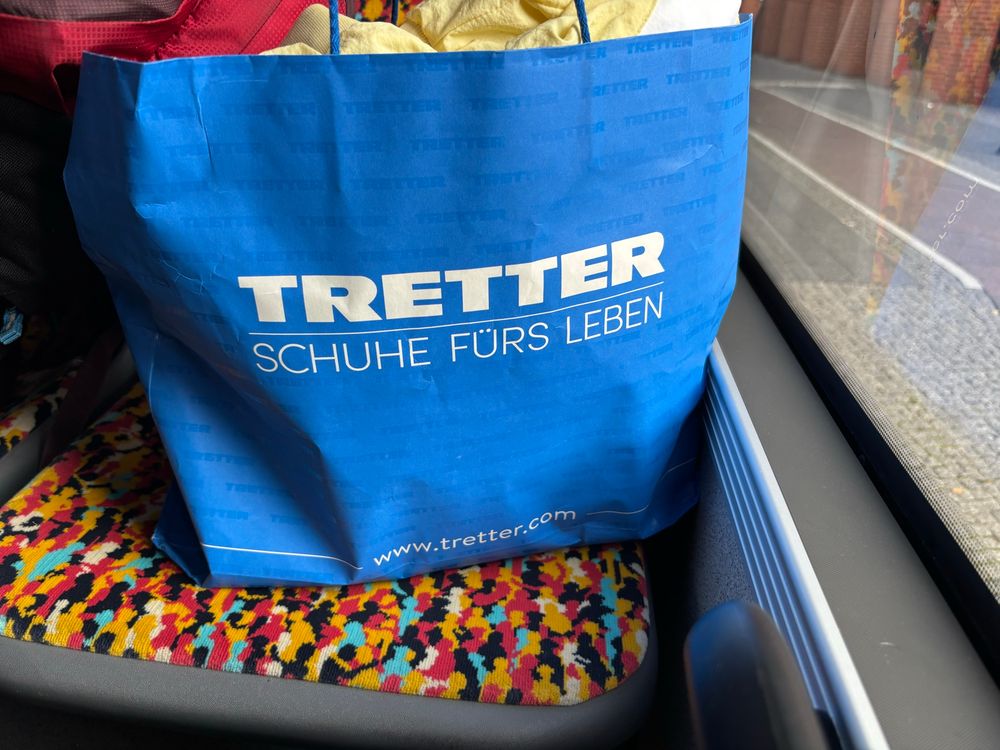 Pappiertüte mit der Aufschrift: TRETTER Schuhe fürs Leben