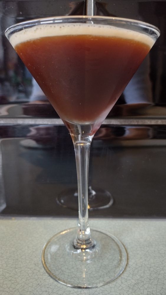 A dark brown Espresso Martini in a cocktail glass.