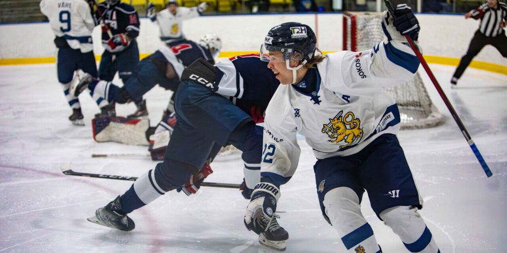 Team Finland player raising his stick as he skates out of the end zone after delivering the championship-winning goal again team USA.