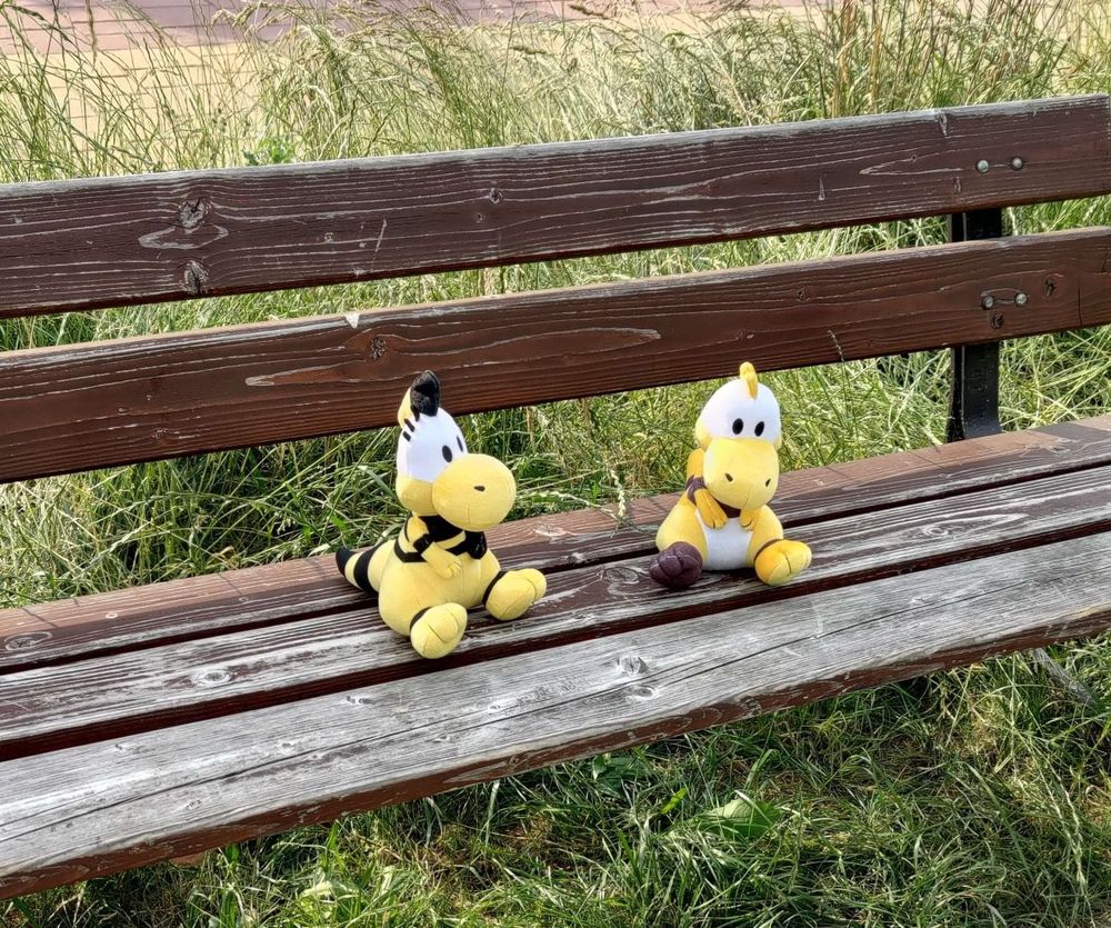 Zid and Zniw plushies chilling on a bench outside