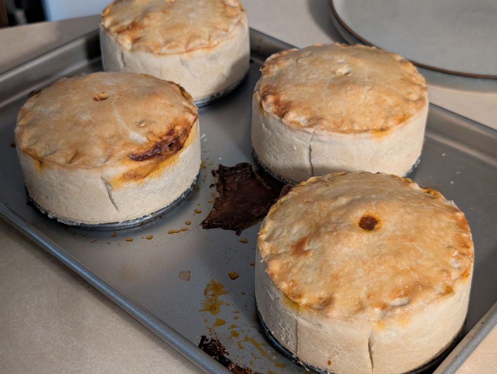 Four 5 inch meat pies fresh out of the oven.