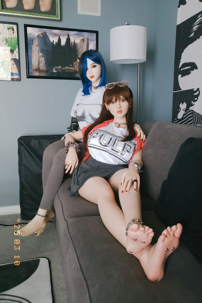 Miss Winter, a companion Doll made by Doll Sweet, and Dyanne Bailey, a companion Doll made by Normondoll, are seated on a charcoal grey sofa. With this photo, however, it's more of a straight-on shot, and the two of them are looking at the viewer. Oh, and Dyanne is wearing a pair of glasses with pink transparent frames on her head. Fun fact: she doesn't actually need those to see properly