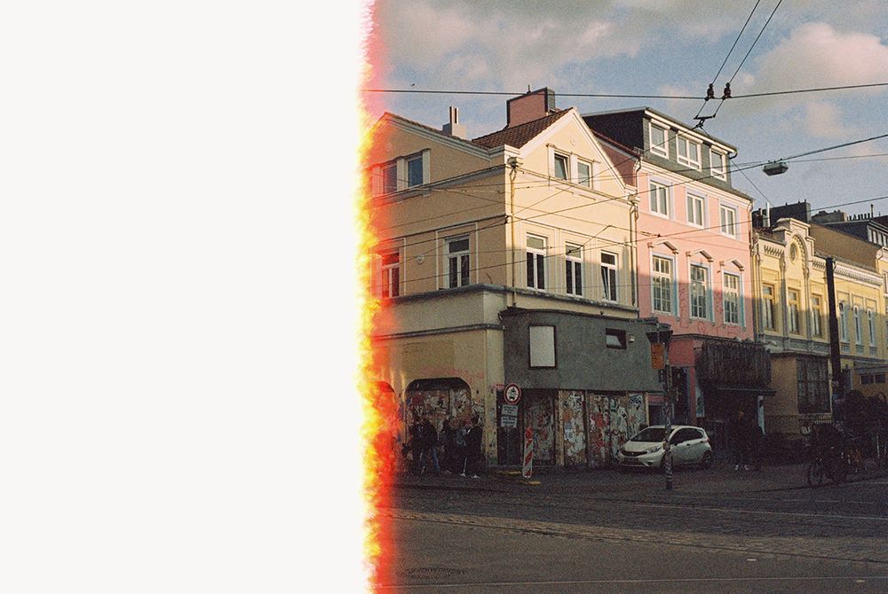 Ein analoges, sehr körniges Foto von einer Straßenecke. Die linke Hälfte vom Bild ist weiß, weil der Film an der Stelle noch nicht belichtet ist.