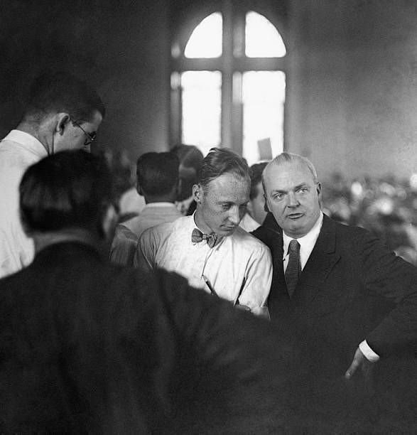 Scopes (bowtie) whispers to defense lawyer Dudley Field Malone as they await the verdict 