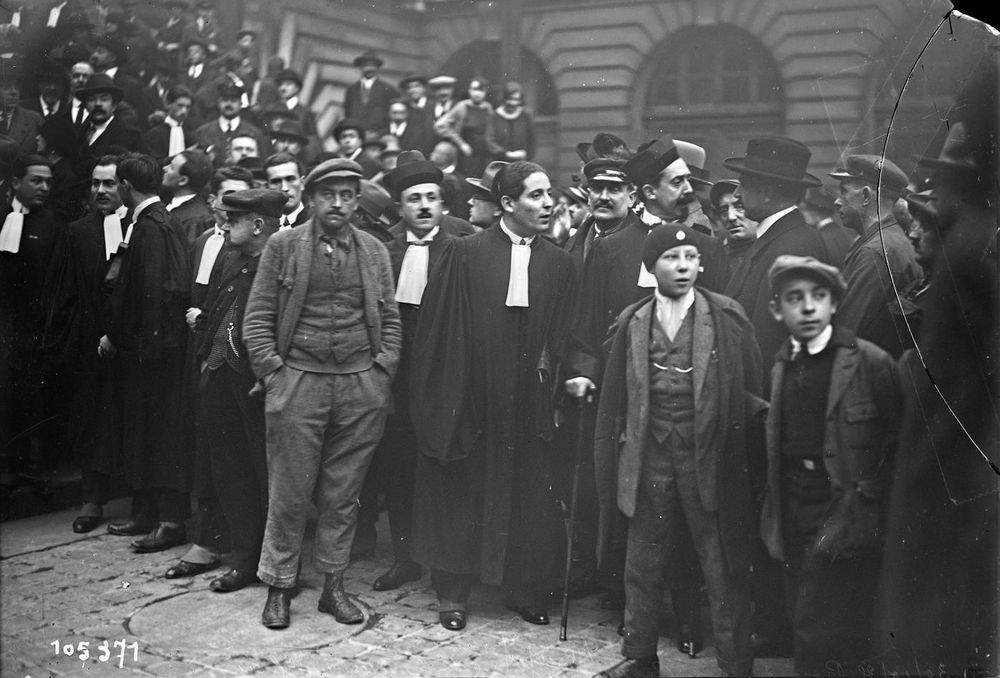 C. Bajot, the cabdriver who is suing Daudet, is seen at far right wearing a peaked cap