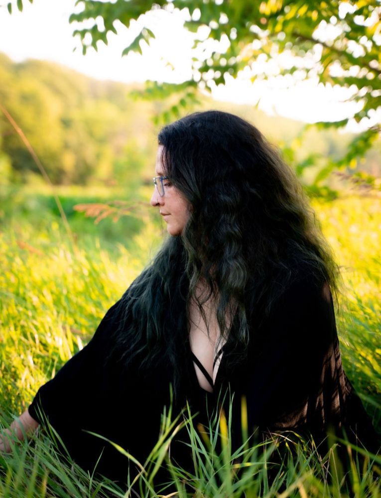Annabel sits in a field of tall grass.