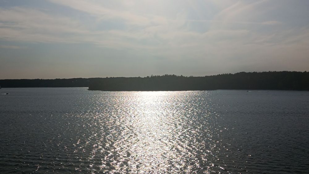 Evening sun reflects off the water in front of wooded islands