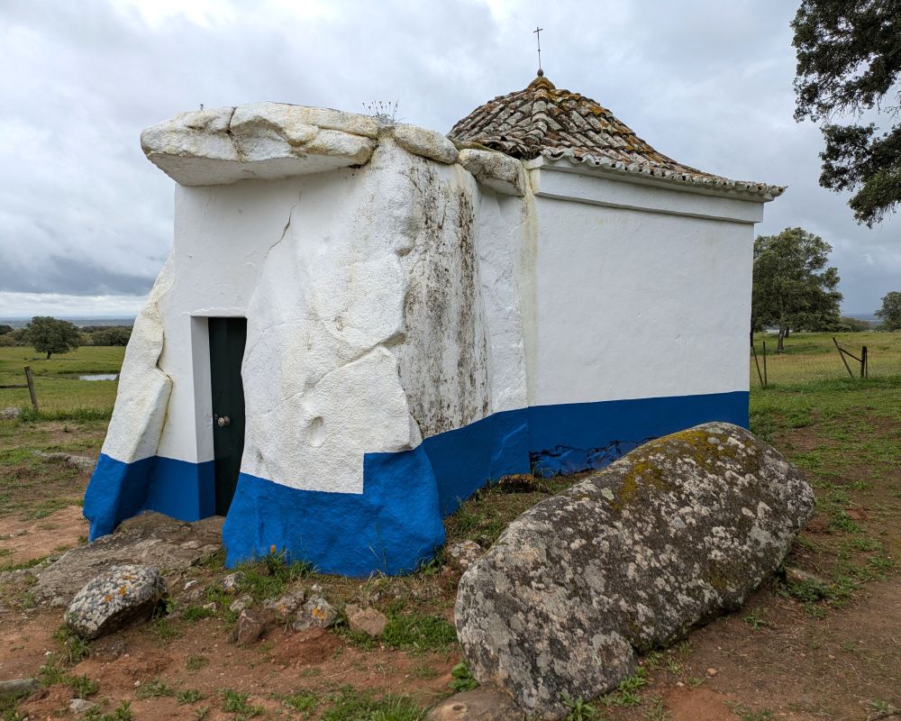 A dolmen-chapel that's been painted blue and white 