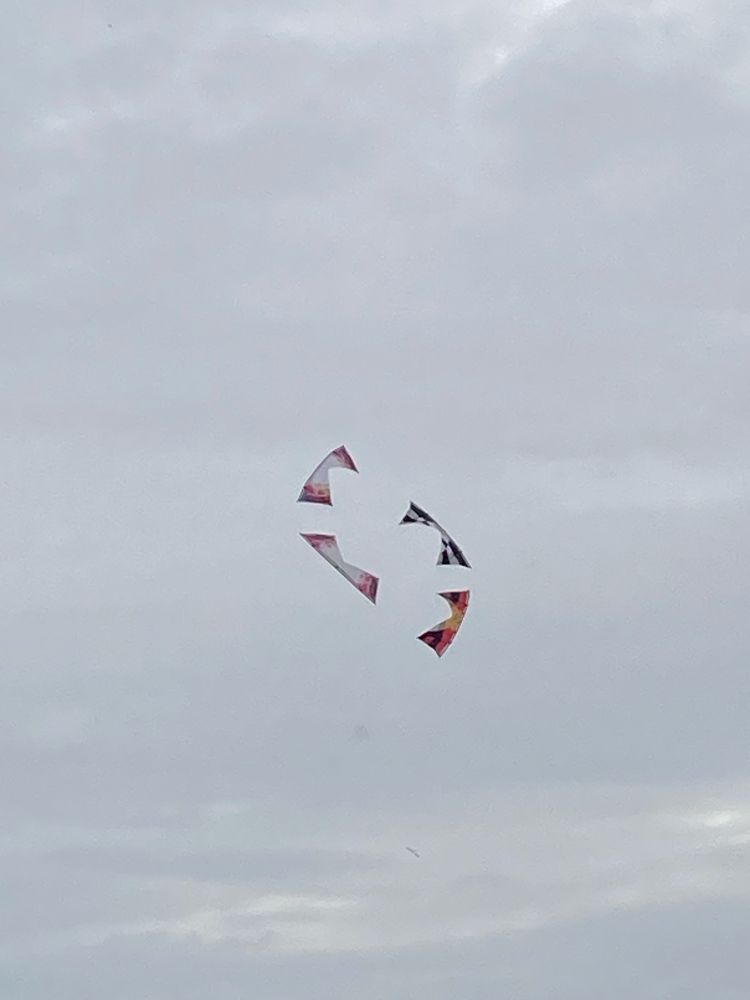 Vier Lenkdrachen in Formation am Himmel.