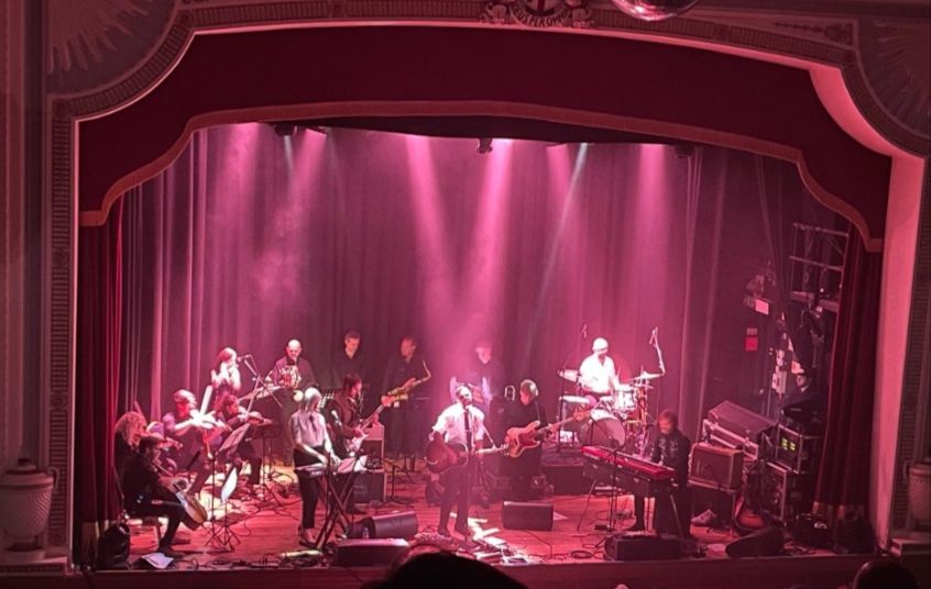 Rock band The Dears on stage with a string quartet and horn section. 