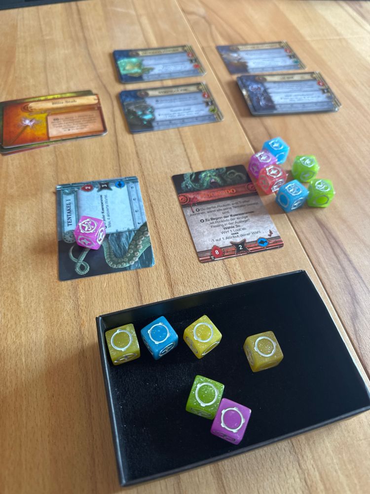 Bunte Würfel und Karten aus dem Spiel „20 Strong“ in der Variante „Too Many Bones“