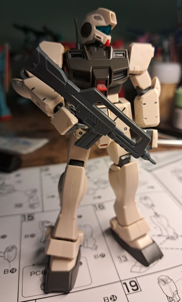 HG GM Command casually holds the Alex's beam rifle in one hand while looking off to the side.