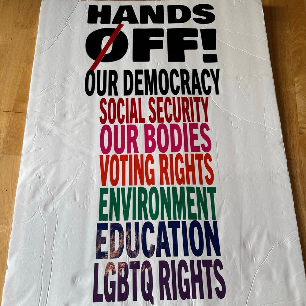 Protest sign with text:

HANDS OFF!
OUR DEMOCRACY
SOCIAL SECURITY
OUR BODIES
VOTING RIGHTS
ENVIRONMENT
EDUCATION
LGBTQ RIGHTS