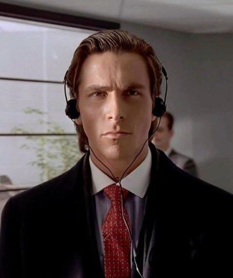 a still of Bateman wearing headphones with a serious face, from the movie Psycho.