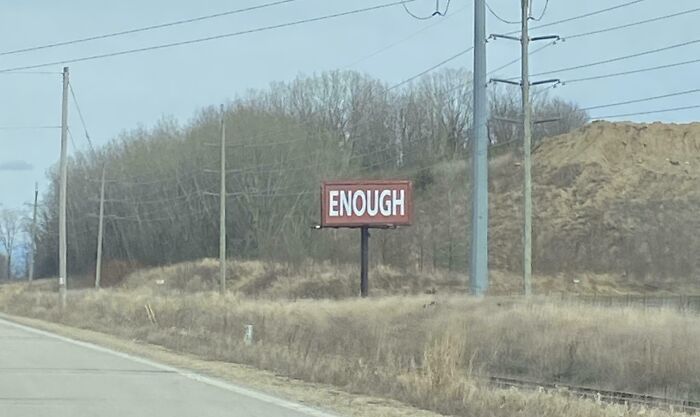 placa de sinalização em estrada com o texto "enough"(o que poderia ser traduzido como "já deu")