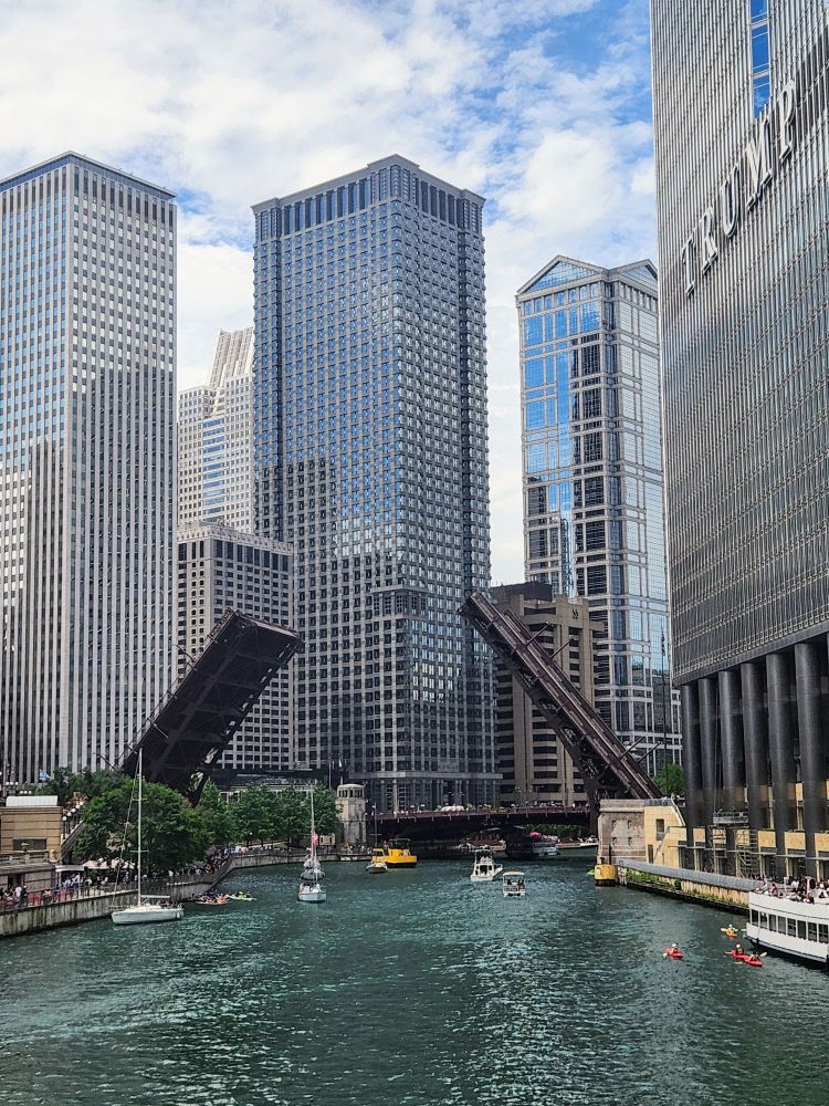Chicago on the river with the buildi gs on either side and boats on the water.