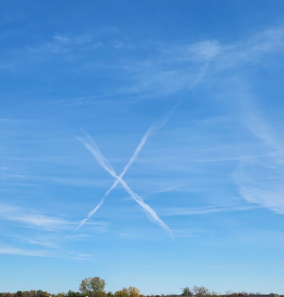 The sky with airplane contrails making an X.