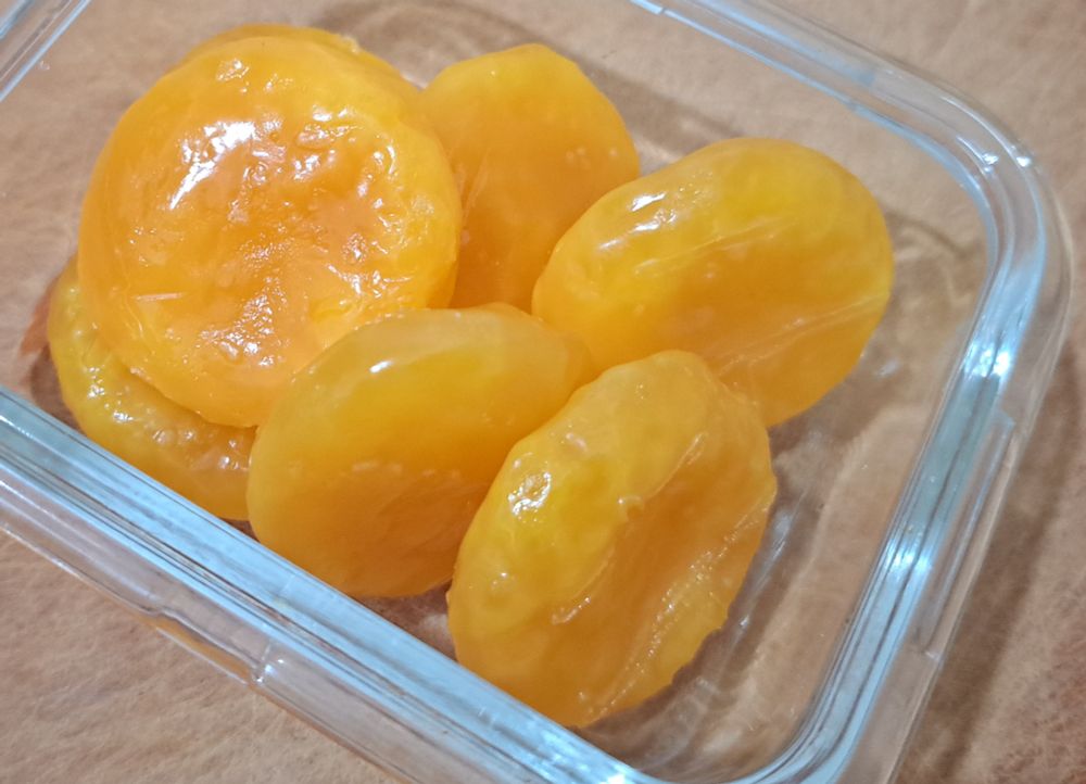 Yellow dried out egg yolks sitting in a small glass container