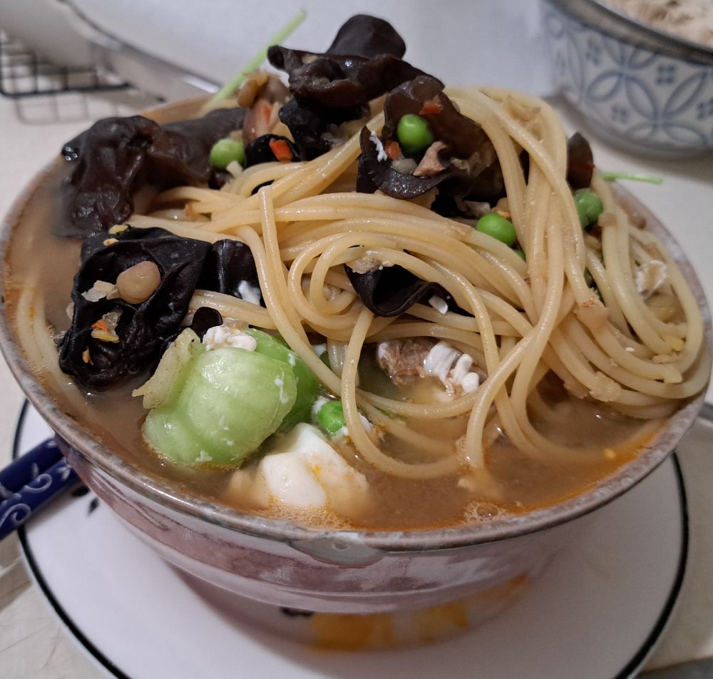 Large bowl of soup with young shanghai bok choy, wood ear fungus, noodles, lentils and tofu. 