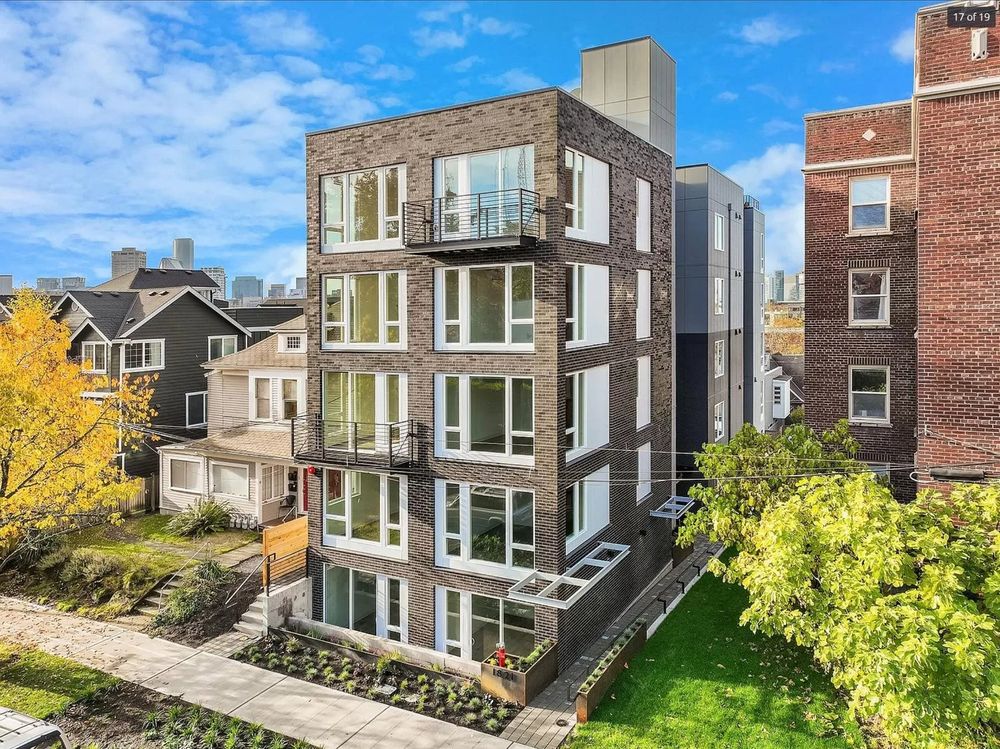 A 5-story single-stair apartment building tucked nicely into a residential neighborhood with greenery, trees, and sidewalks
