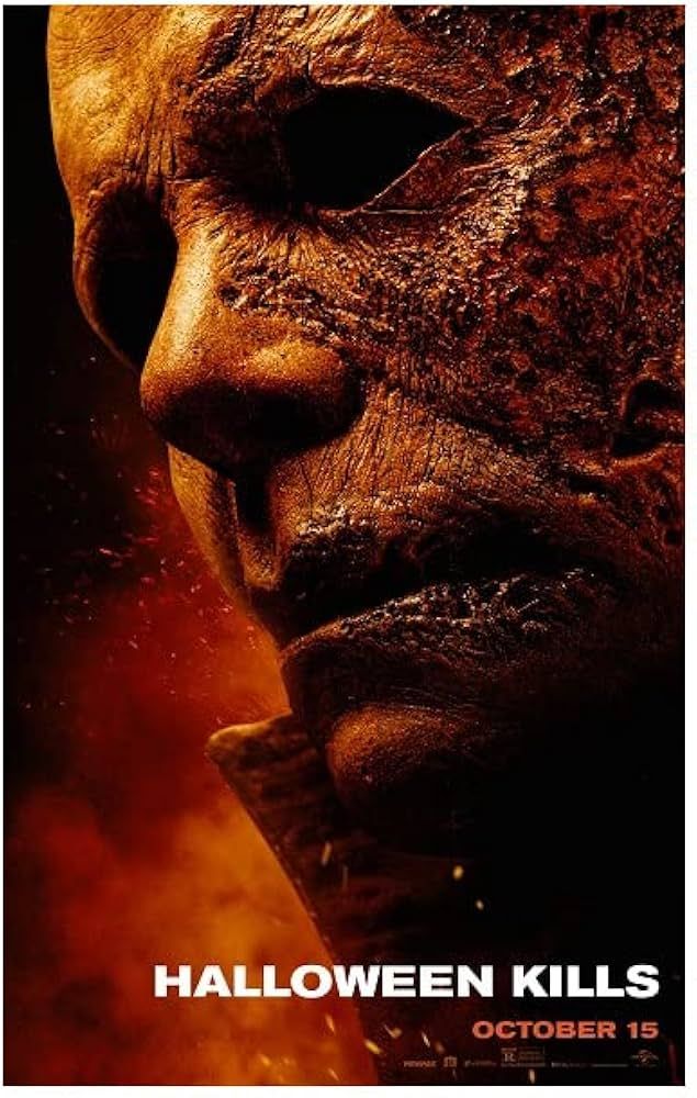 The cover for Halloween Ends, depicting Michael Myers Mask with some meltedness to it as he stares off to the left with a firey background behind him