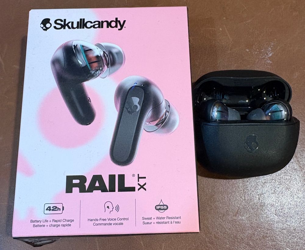 A box of Skullcandy Rail XT earbuds and the earbuds themselves in a case next to it