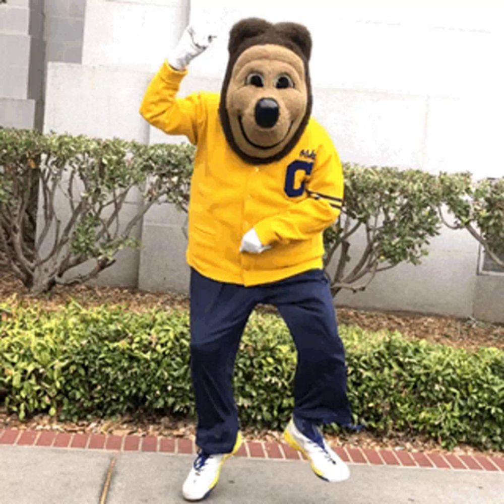 a mascot wearing a yellow jacket with the letter c on the front